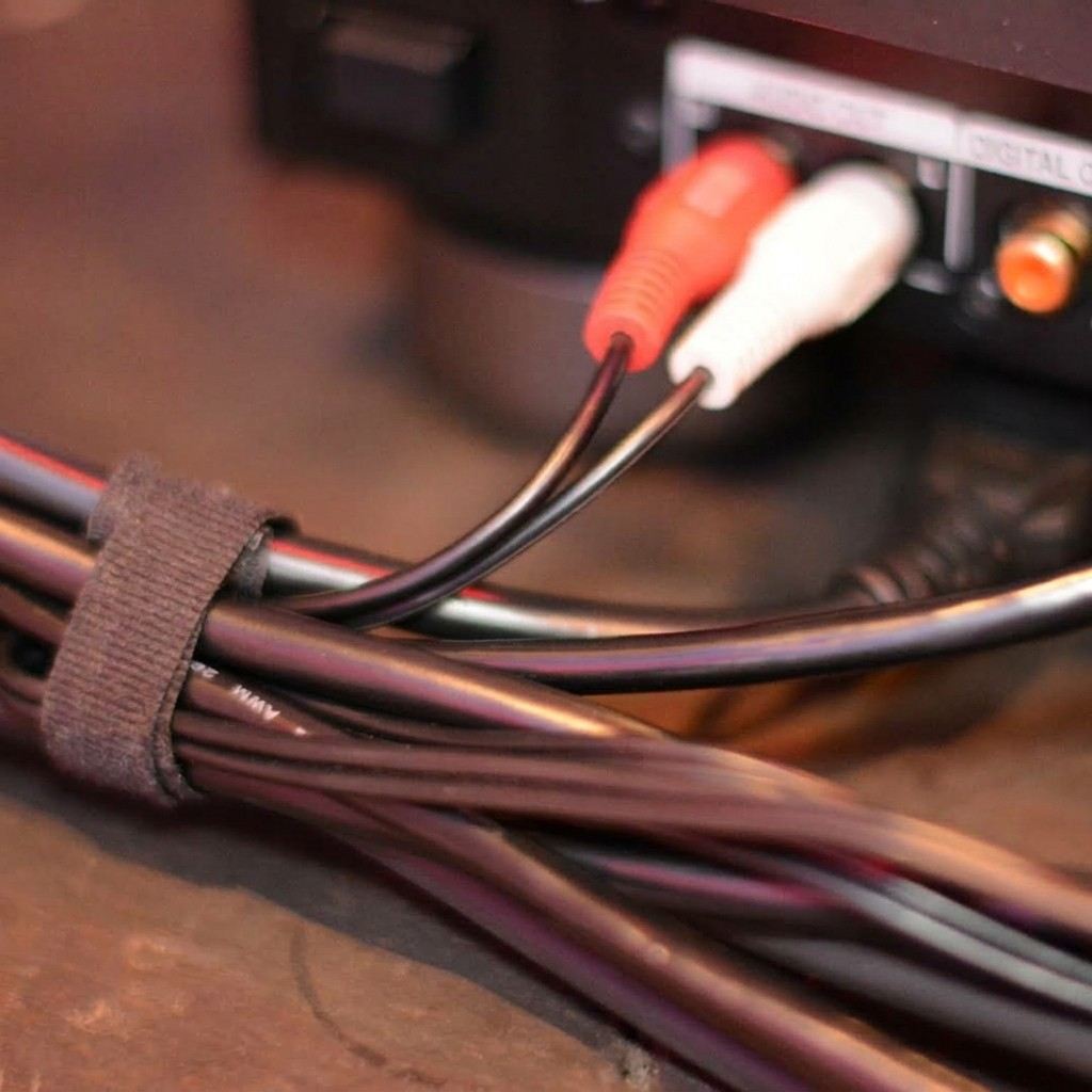 Cabos de áudio organizados e conectados a um equipamento de som