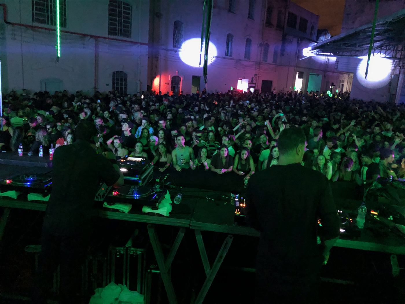Pista cheia à noite com equipamentos para DJ da Dínamo